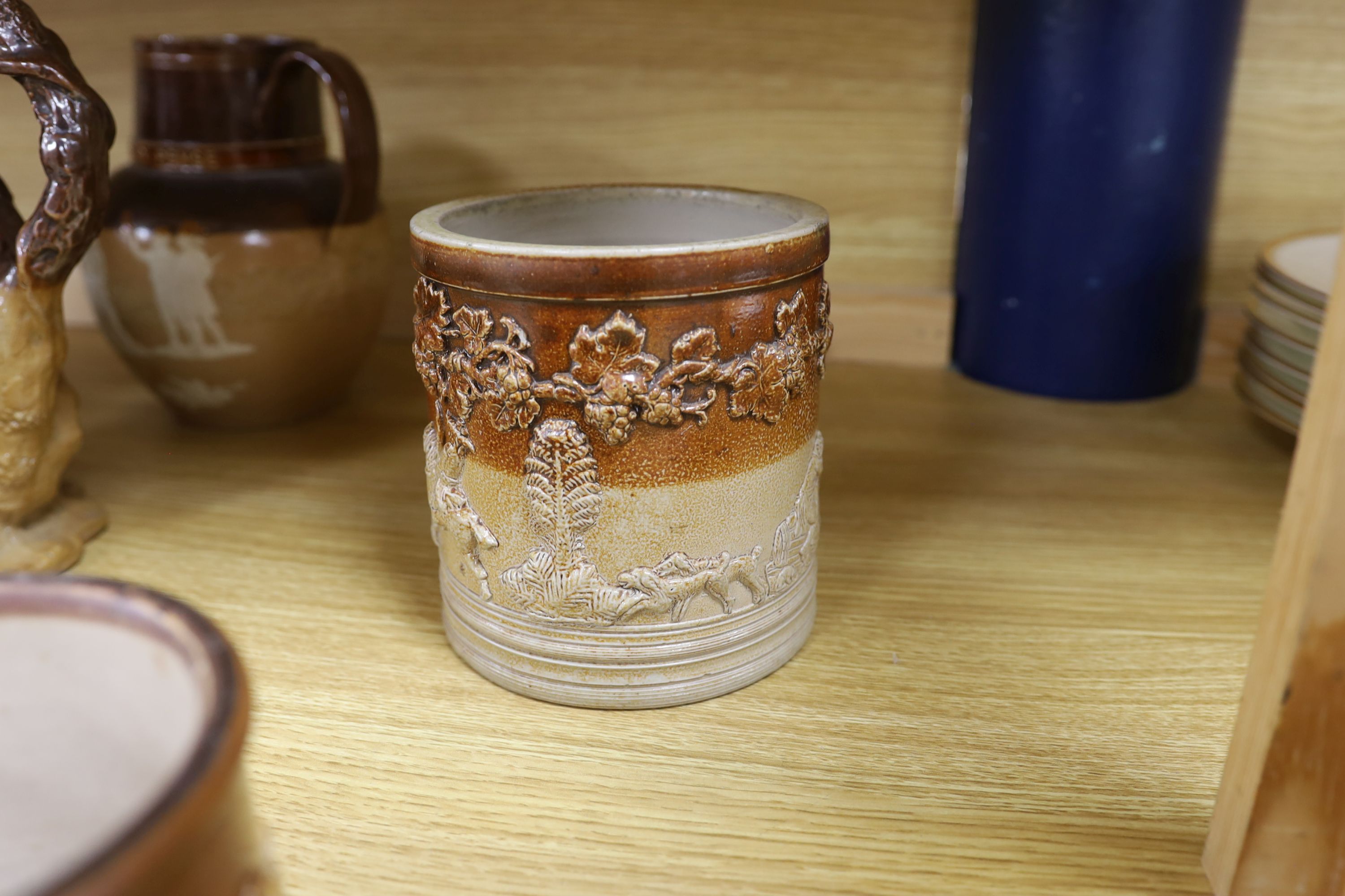 A Victorian stoneware jug, the sides moulded with bacchanalians, together with other earthenware jugs, a white salt glazed dish and 'house' teapot, the latter lacking lid, the largest 23cm high